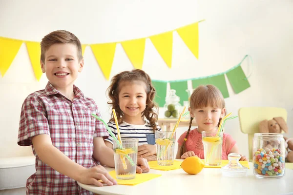 Schattig weinig kinderen drinken limonade aan tafel — Stockfoto