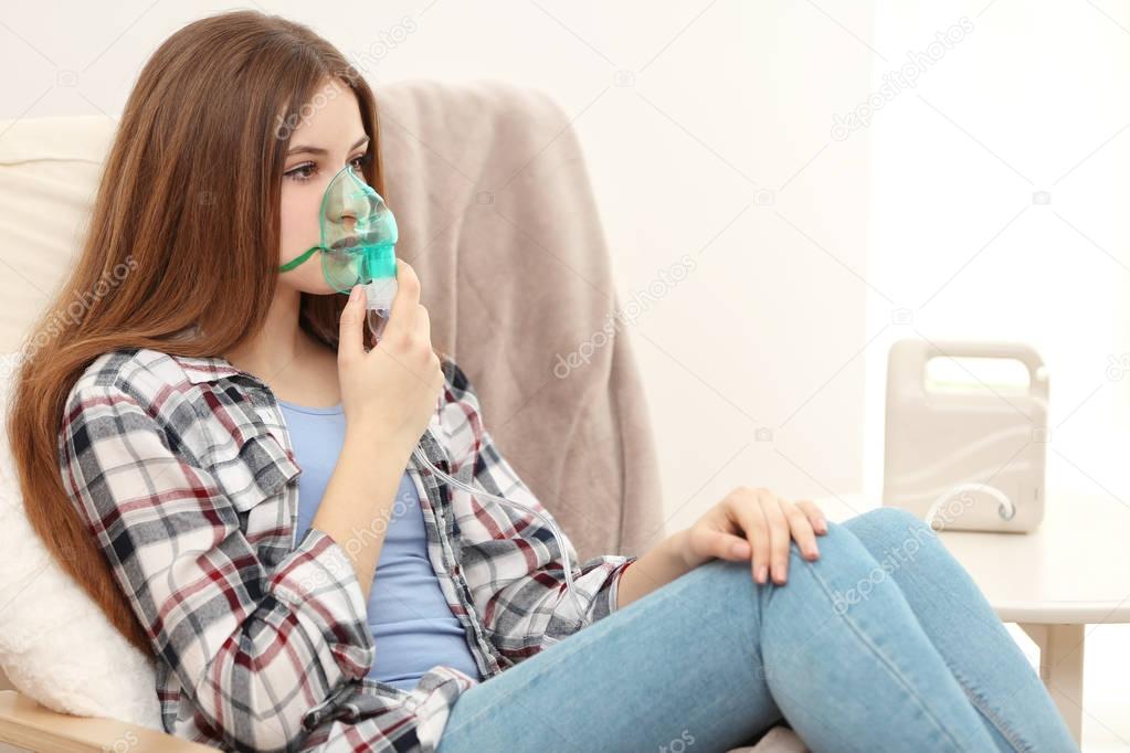 Young woman using nebulizer