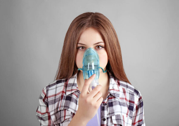 Молодая женщина, использующая распылитель
 