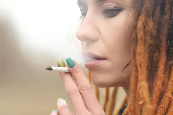 Young beautiful woman smoking weed