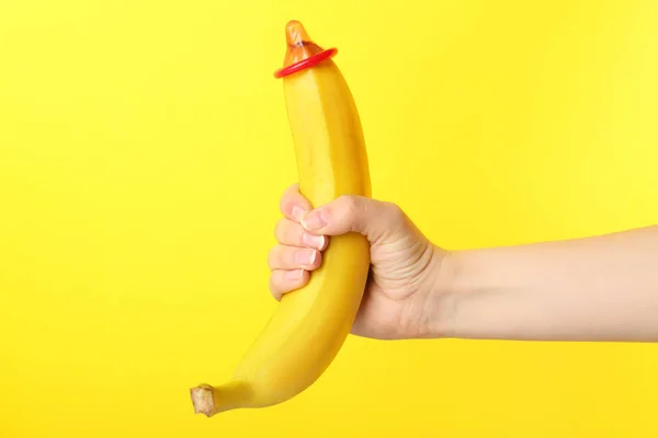 Mulher segurando banana com preservativo — Fotografia de Stock