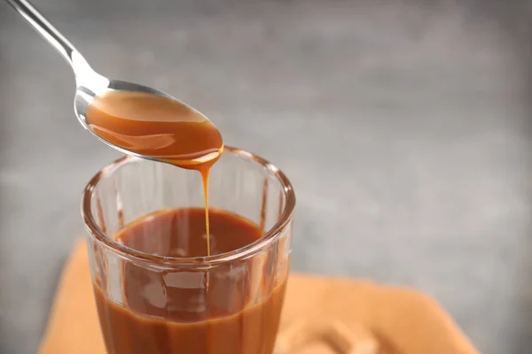 Menuang saus karamel ke dalam gelas makanan penutup — Stok Foto