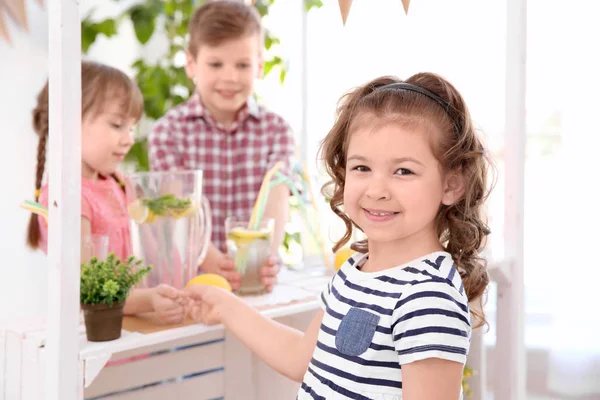Söt liten flicka att köpa lemonad från kids i monter — Stockfoto