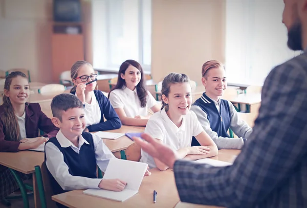 Kinderen luisteren leraar in de klas op school — Stockfoto