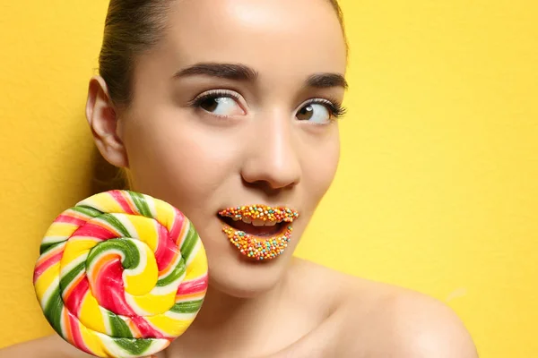 Beautiful young woman holding lollipop near lips — Stock Photo, Image