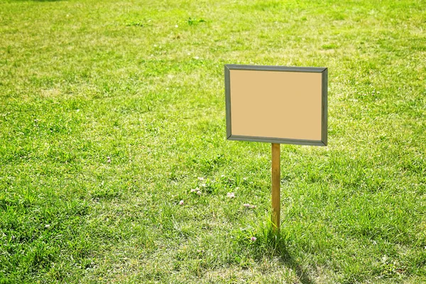 Blank board on green lawn — Stock Photo, Image