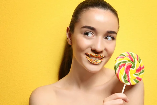 Vacker ung kvinna som innehar lollipop nära läppar — Stockfoto