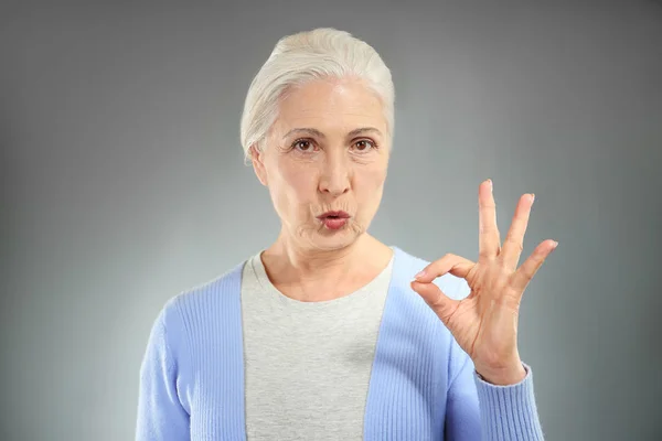 Bejaarde vrouw weergegeven: ok gebaar — Stockfoto