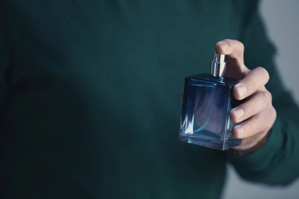 Young man with bottle of perfume — Stock Photo, Image