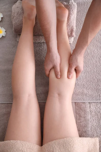 Genç kadın masaj bacakları olan — Stok fotoğraf