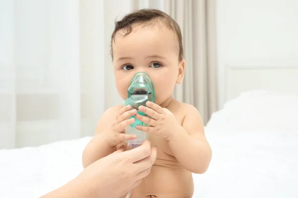 Anne evde yatakta oturup şirin bebek için Nebulizatör kullanarak. Sağlık kavramı — Stok fotoğraf