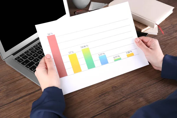 Kobieta trzyma arkusz papieru z diagramu — Zdjęcie stockowe