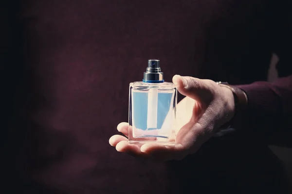 Young man with bottle of perfume — Stock Photo, Image