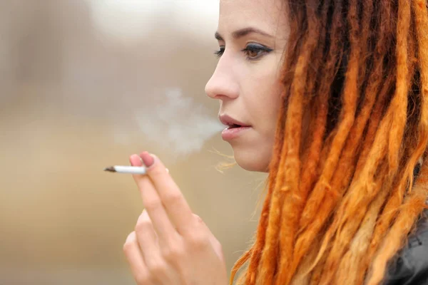 Νεαρή όμορφη γυναίκα καπνίζοντας ζιζάνιο — Φωτογραφία Αρχείου
