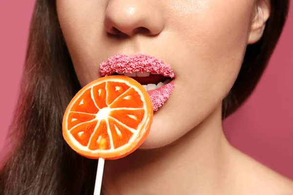 Beautiful young woman holding lollipop near lips — Stock Photo, Image