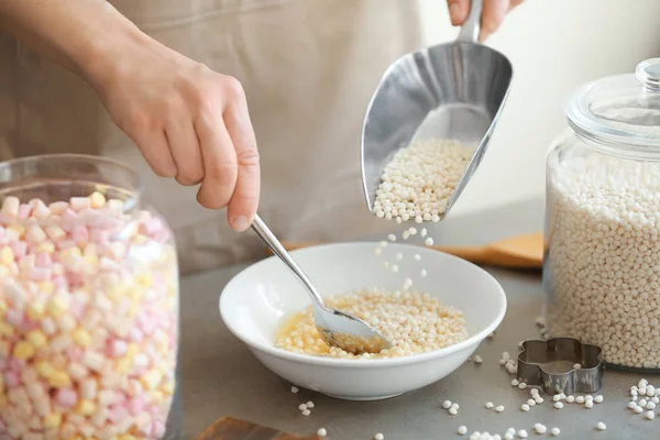 Vrouw krokante rijst ballen toevoegen — Stockfoto