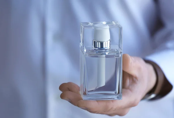 Young man with bottle of perfume — Stock Photo, Image