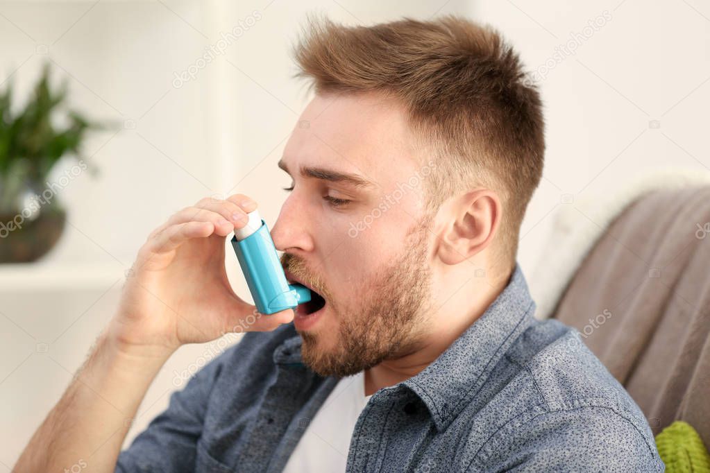 Young man using inhaler 