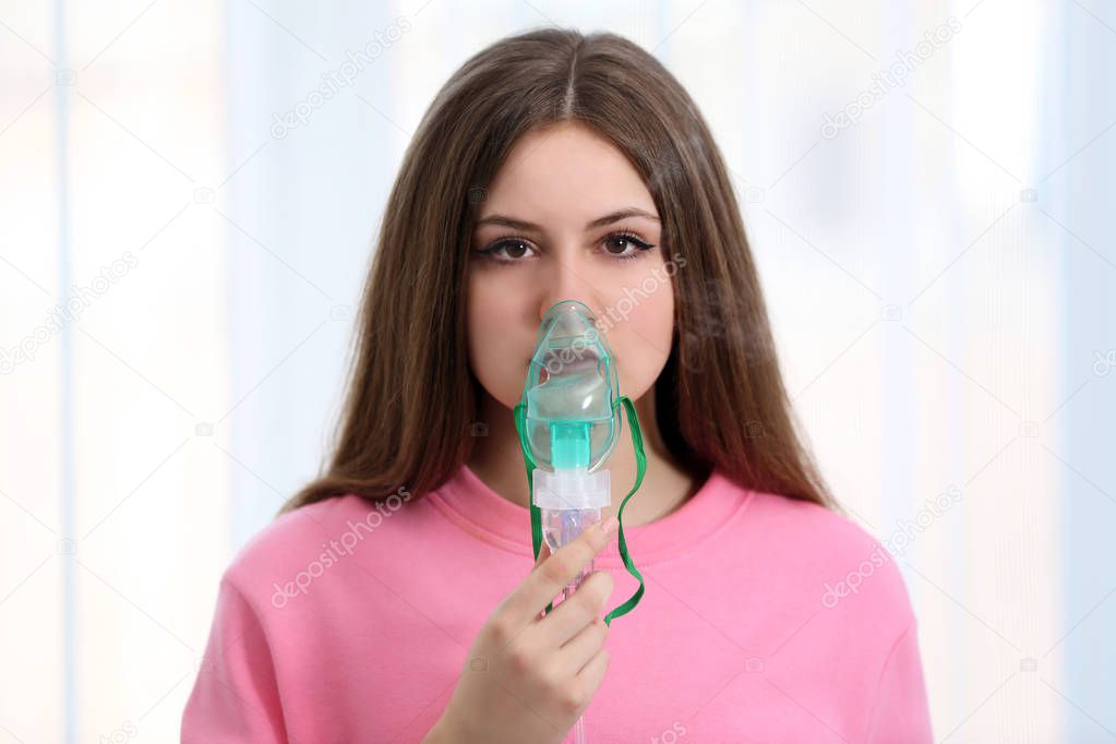 Young woman using nebulizer