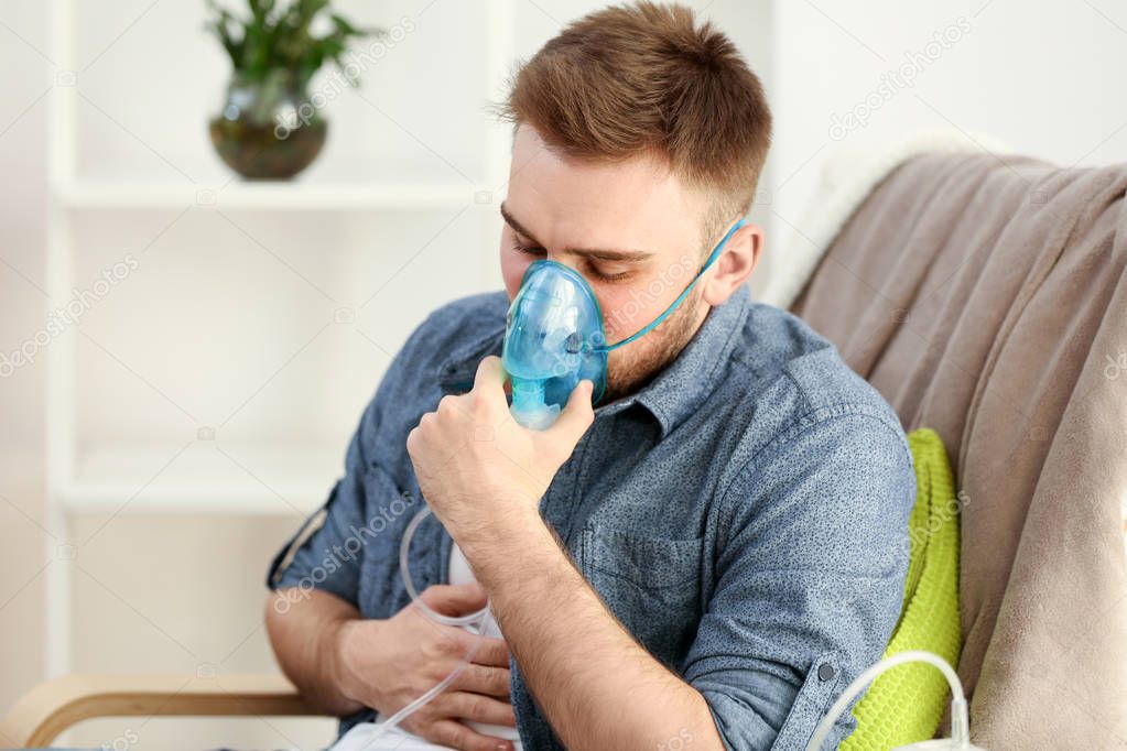 Young man using nebulizer 