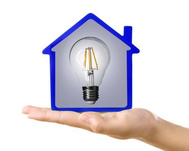 Model ev ve ampul beyaz arka plan üzerinde tutan kadın. Enerji tüketimi kavramı