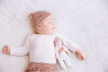 Şirin bebek oyuncak tavşanlı ekose evde uyuyor