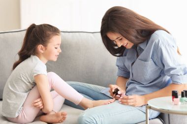 Genç kadın ve küçük kızı evde pedikür yapıyor