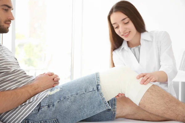 Médico aplicando vendaje en la pierna — Foto de Stock