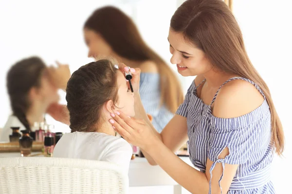 Ung kvinna att göra upp hennes dotter hemma — Stockfoto