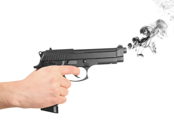 Человек держит дымящийся пистолет на белом фоне — стоковое фото