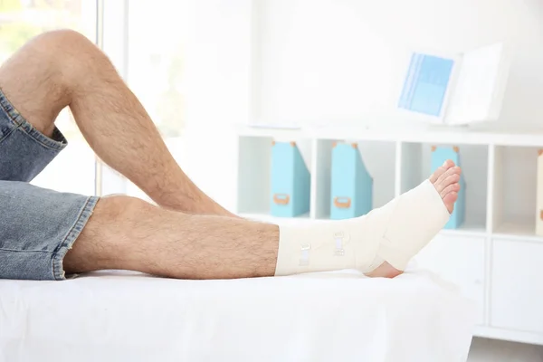 Mann mit bandagiertem Bein — Stockfoto