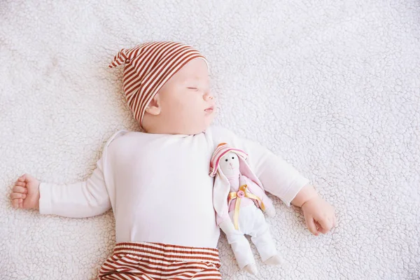 Lindo bebé con conejito de juguete durmiendo en cuadros en casa —  Fotos de Stock