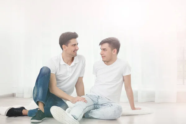 Gay par sitter på golvet — Stockfoto