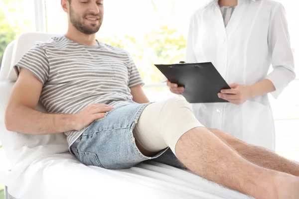Junger Mann mit bandagiertem Bein — Stockfoto