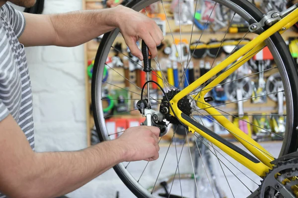 Joven trabajando en taller de reparación de bicicletas —  Fotos de Stock