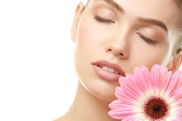 Closeup view of beautiful young woman with natural lips makeup and flower on white background — Stock Photo, Image