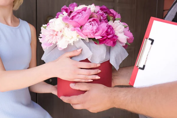 Frau erhält schöne Pfingstrosenblumen — Stockfoto