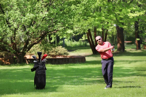 Hombre joven jugando al golf en el campo en un día soleado —  Fotos de Stock