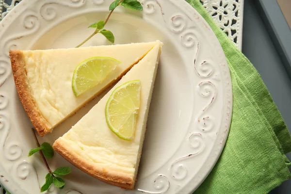 Placa con deliciosas rebanadas de pastel de queso — Foto de Stock