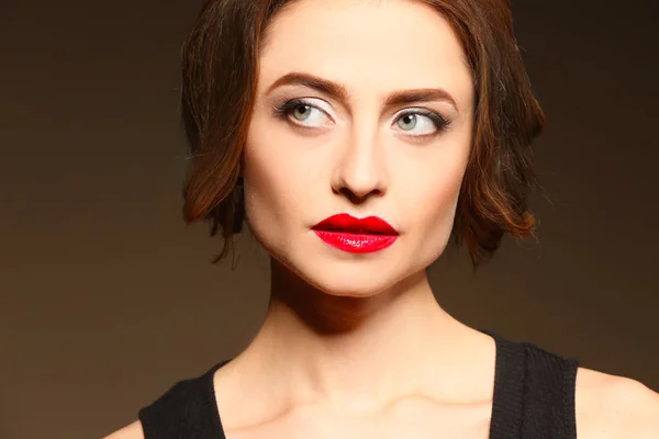 Hermosa joven con labios brillantes sobre fondo oscuro — Foto de Stock