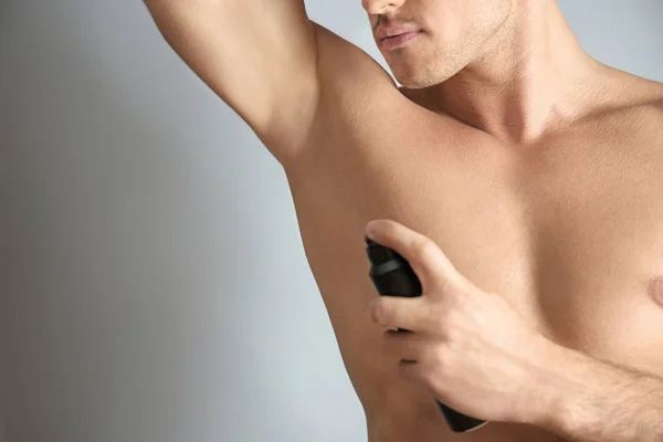 Mladý muž s deodoranty — Stock fotografie