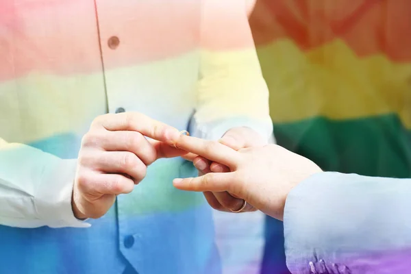 Hombre poniendo anillo de bodas en el dedo del novio —  Fotos de Stock