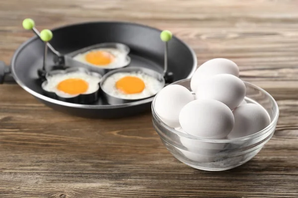 Fried eggs on wooden table — Stock Photo, Image