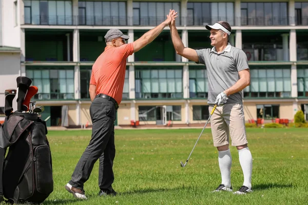 Hombres jóvenes en el campo de golf en un día soleado — Foto de Stock