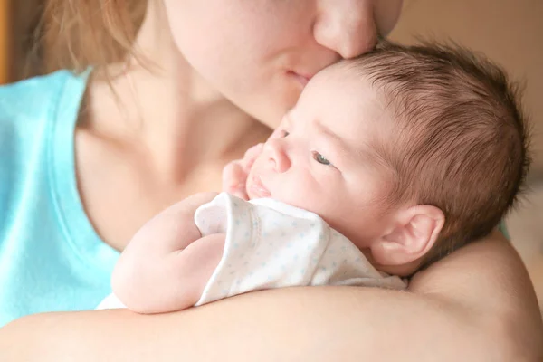 Glückliche junge Frau küsst ihr neugeborenes Baby, Nahaufnahme — Stockfoto