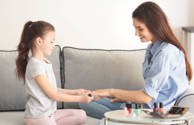 Genç kadın ve küçük kızı evde tırnaklarını