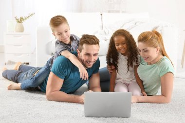 Aile kavramı evde, Online alışveriş internet Mağazası gözatmak için dizüstü bilgisayar kullanarak