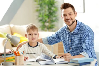 Baba ve oğul ödev yapıyor.