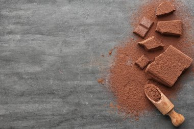 Kıyılmış çikolata parçaları, kakao tozu ve tablo üzerinde ahşap Kepçe