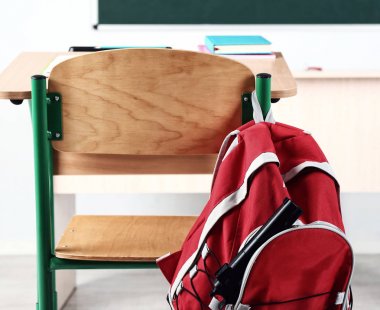 Sandalyeye asılı silahla sırt çantası